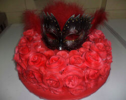 Mask on red rose cake